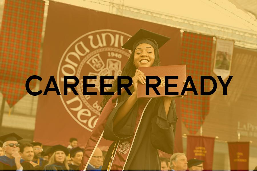 A student smiles and crosses the stage with her diploma.