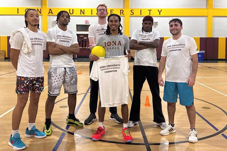 The intramural dodgeball team holds up their t-shirts.