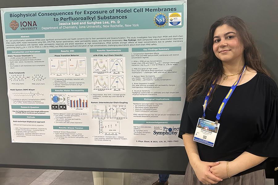Jessica Said standing and smiling next to research project board.