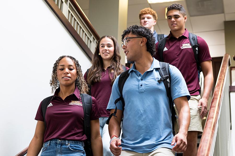 Students walk down the stairs in the library.