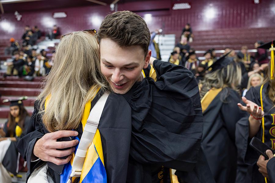 Two graduates embrace before the ceremony.
