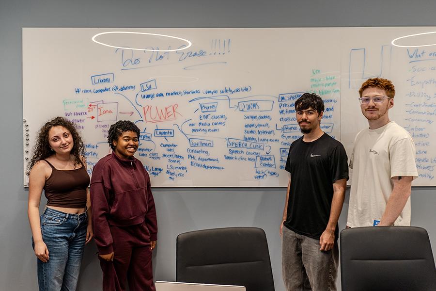 Students in front of their whiteboard for Education in Real Life.