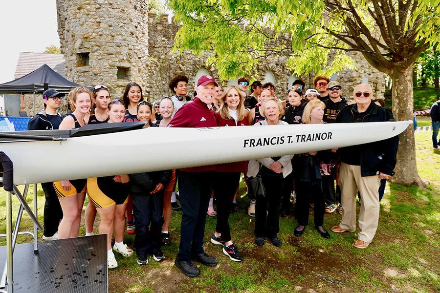 The Trainors with the new shell and members of the rowing teams.