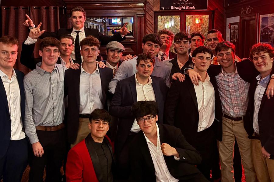 Members of Zeta Kappa Chi in suits at a formal party.