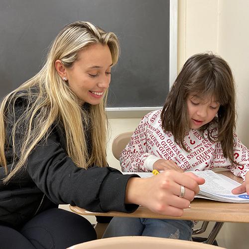 Amanta Krasniqi ’22, an adolescent education major at Iona College, reads with Valentina Oroco, a third grader at William B. Ward Elementary School in New Rochelle.