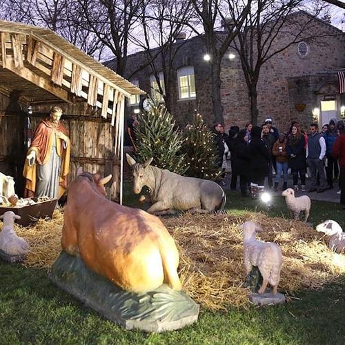 Members of the Iona Community gather around the Chreche to ring in the holidays and sing.