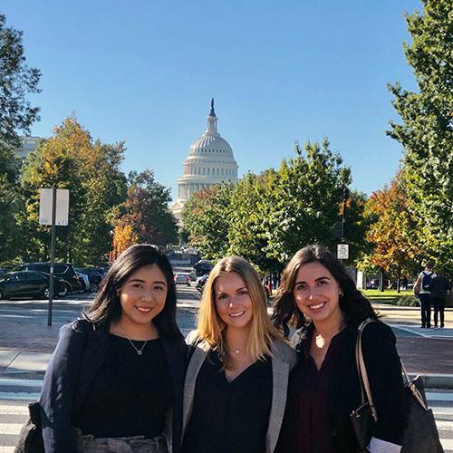 Allison Lopez, Julie Stohr and Nicole Genser pose with the capital building in the background.