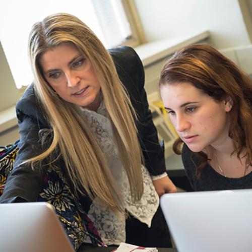 Paolina Centonze helps a student at a computer.