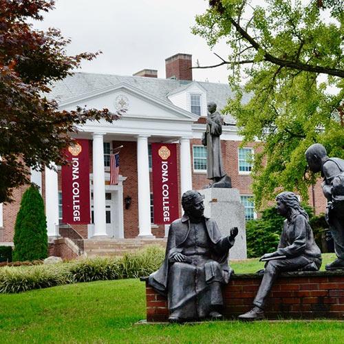 The "To Teach" statue in the Iona campus quad with McSpedon Hall in the background