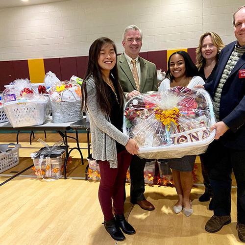 Faith Krefft, President of Iona University Seamus Carey, Ph.D., Tamia Reyes, Noreen Carey and Carl Procario-Foley hold a basket at the 2019 Thanksgiving Baskets event.