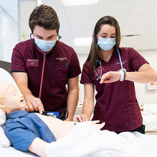 Iona nursing students practice with the stethoscope on a mannequin.