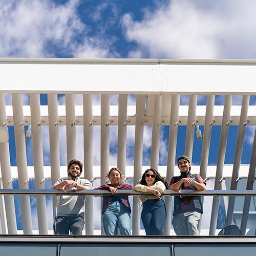 Four students on the terrace of the LaPenta School of Business.