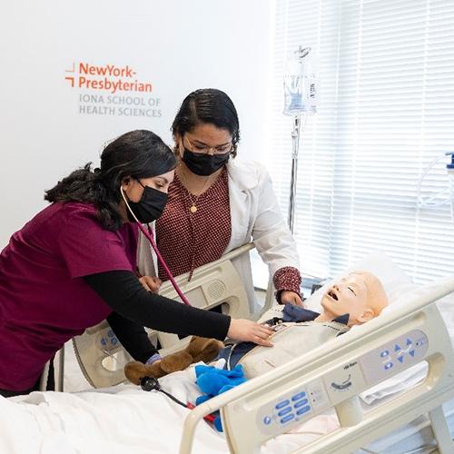 A nursing student and a professor practice on a mannequin in the lab.