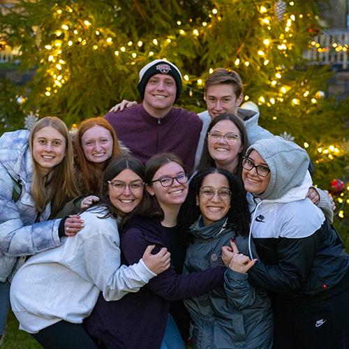 Iona students in front of the Christmas tree on campus.