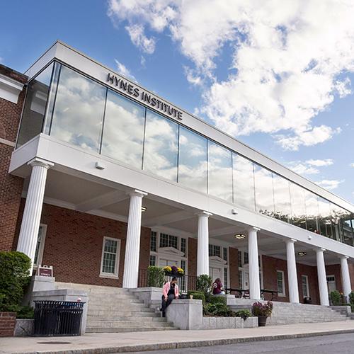 The Hynes Institute on a sunny day with clouds floating above.