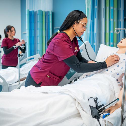 Students in the nursing education program work in the simulation lab.
