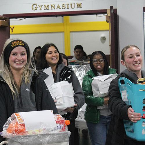 Students bring Thanksgiving baskets from Mulcahy to the vans.