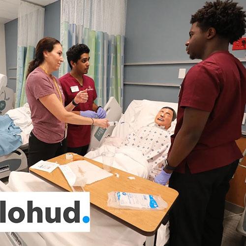 Nursing students attending to patient with lohud logo