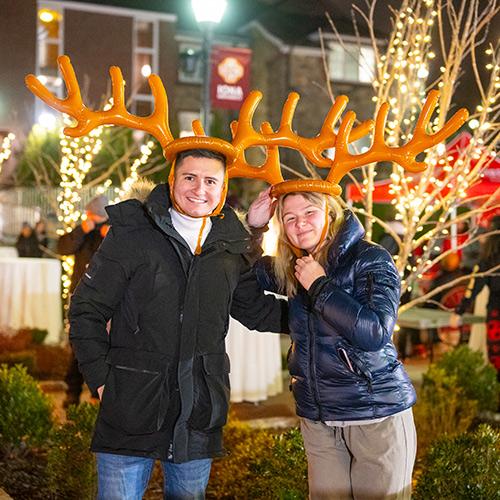 Two students with reindeer antlers at a Christmas party.