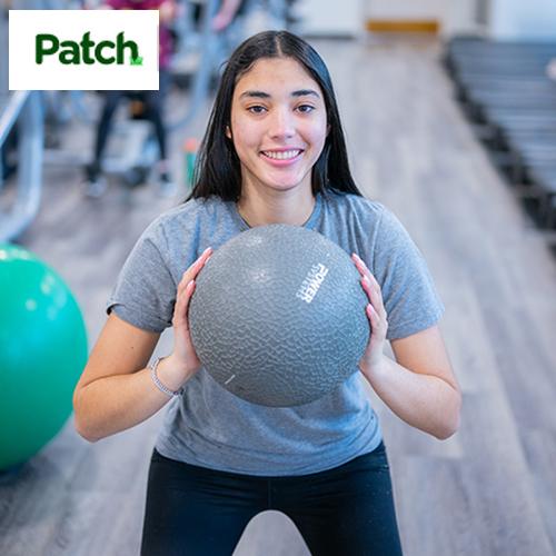 A student exercises with a medicine ball with the Patch logo in the corner.