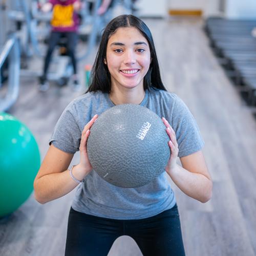 A student exercises with a medicine ball.