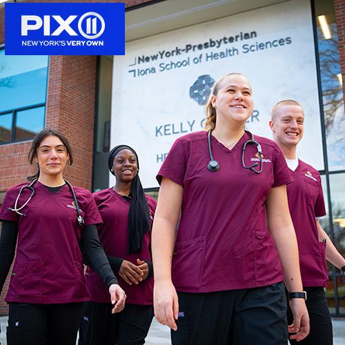 Four students walk by the entrance of the Kelly Center.