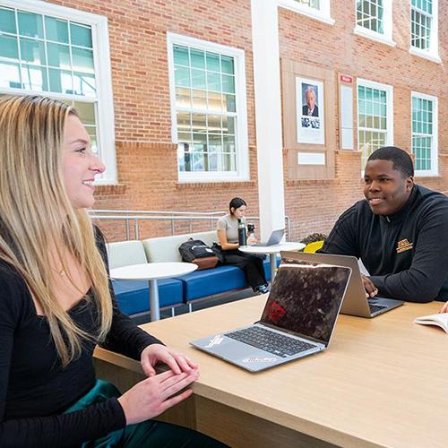 Two students study in the LaPenta School of Business.