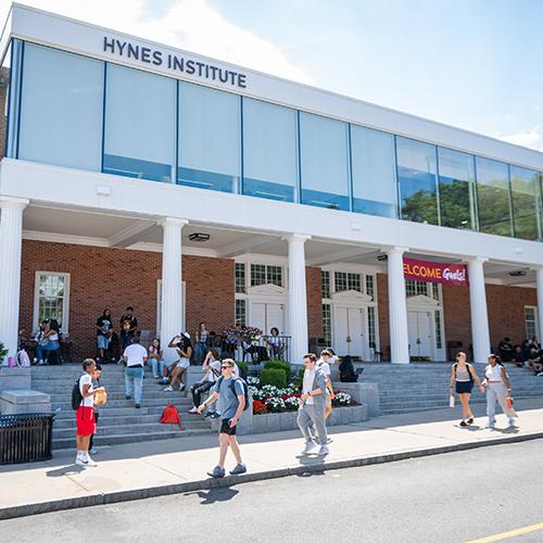 Exterior photo of the Hynes Institute building at the Iona University New Rochelle campus with students walking in front of the building during the day.