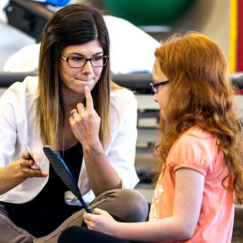 A speech therapist helping a young patient.