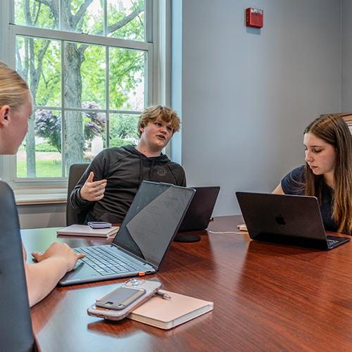 Students work in a board room setting for Education in Real Life.