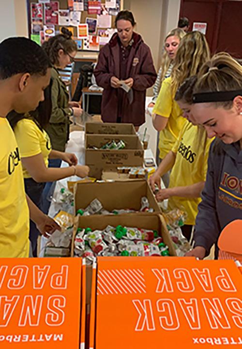 Students work to fill boxes with food for One Million Acts of Good.