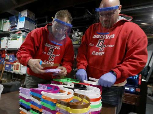 Anthony Rich and David O’Neil assemble face shields.