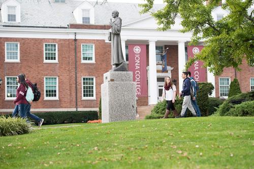 Iona students walk past the Columba statue in front of McSpedon Hall.