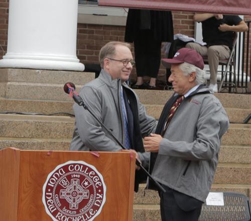 Past president Nyre shakes hands with Robert LaPenta at the announcement ceremony for the LaPenta School of Business.