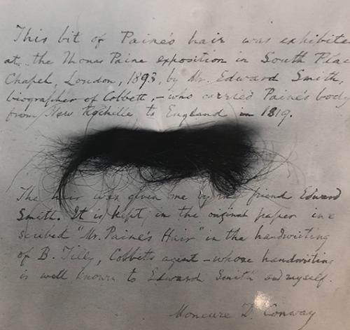 A Piece of Thomas Paine's hair on top of an old letter but the letter is not legible.
