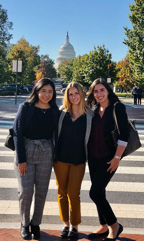 Allison Lopez, Julie Stohr and Nicole Genser pose with the capital building in the background.