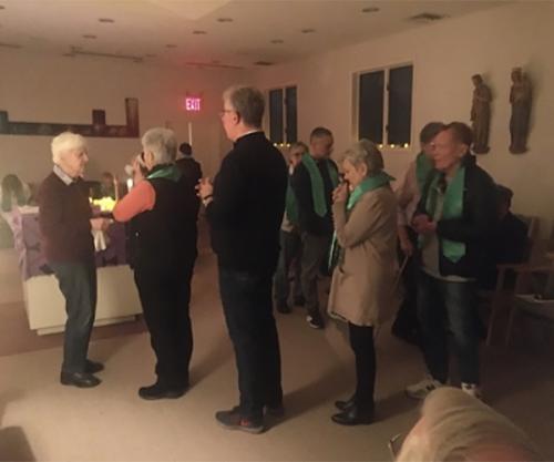 Several people line up to receive the Eucharist at an Advent Mass held in the Iona University Chapel.