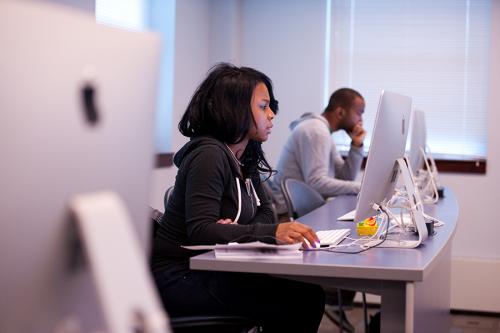 A student works on an Apple/Mac desktop in the computer lab.