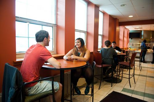 Two students sit talking in the LaPenta Marketplace.