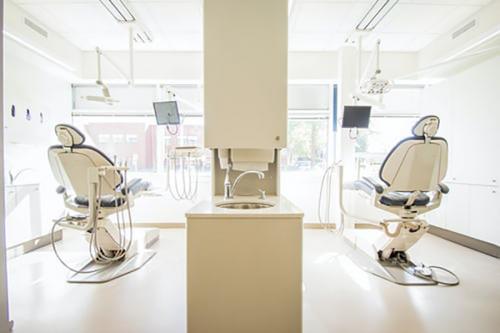 Two dentist chairs in a dental office.