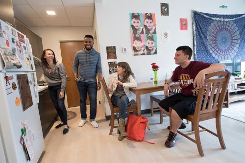 Four Iona students hang out in the kitchen area of their living learning community.