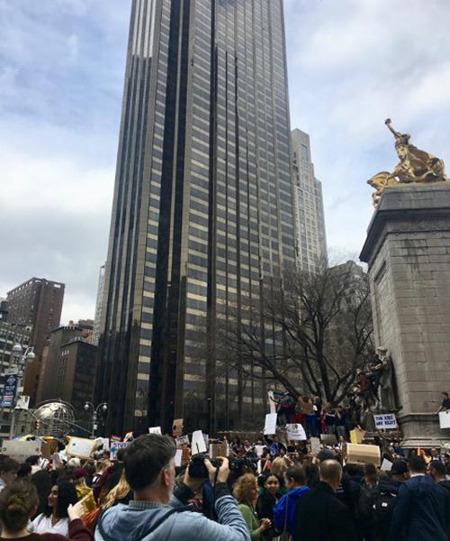 Demonstrators for climate change gather in front of a skyscraper.