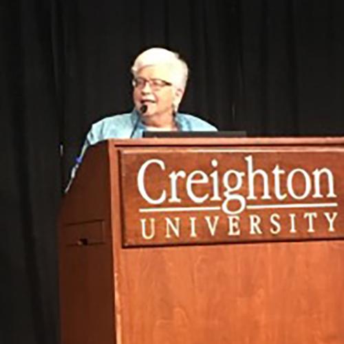 Sister Pat Siemen stands and speaks at a podium at Creighton University.