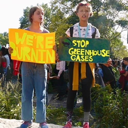 Two children hold posters in support of climate change.