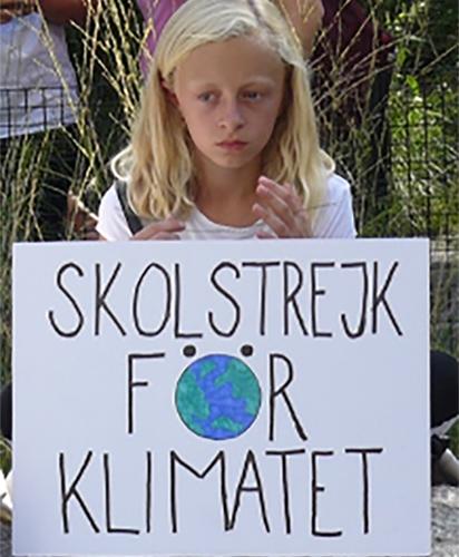 A young girl holds a poster in support for climate change.