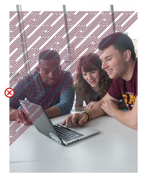 Three students sit together and look at a laptop screen. Celtic line art runs diagonally over the top half of the image, blocking the students.