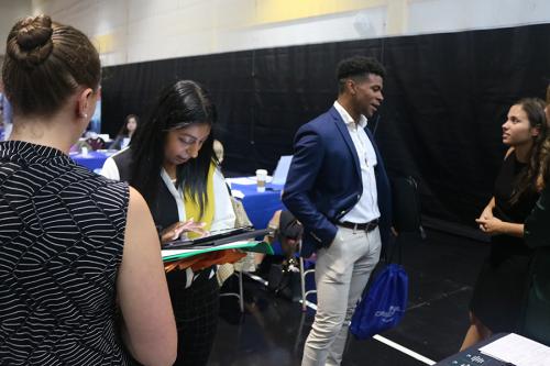 Students and professionals network at the career fair.