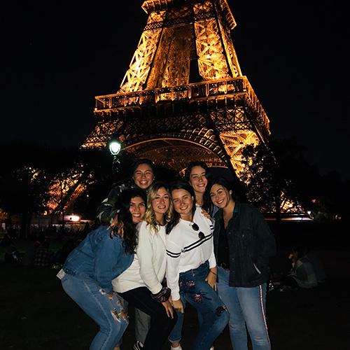 A group of Iona students in front of the Eiffel Tower at night in Paris, France.