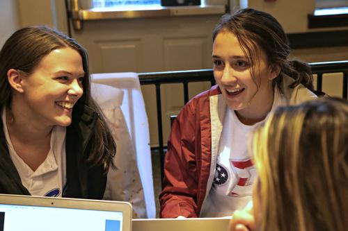 Two female students talk at a table in Starbucks.