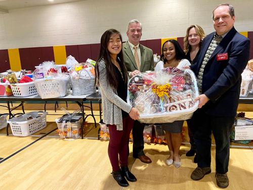 Faith Krefft, President of Iona University Seamus Carey, Ph.D., Tamia Reyes, Noreen Carey and Carl Procario-Foley hold a basket at the 2019 Thanksgiving Baskets event.